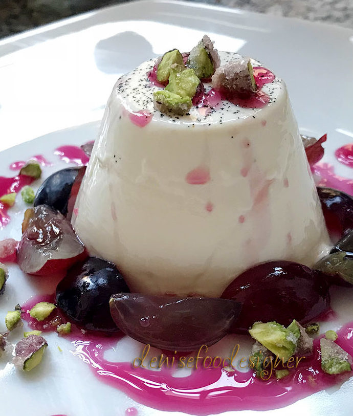 VANILLA PANNA COTTA WITH GRAPES, CANDIED PISTACHIOS AND POMEGRANATE SYRUP.